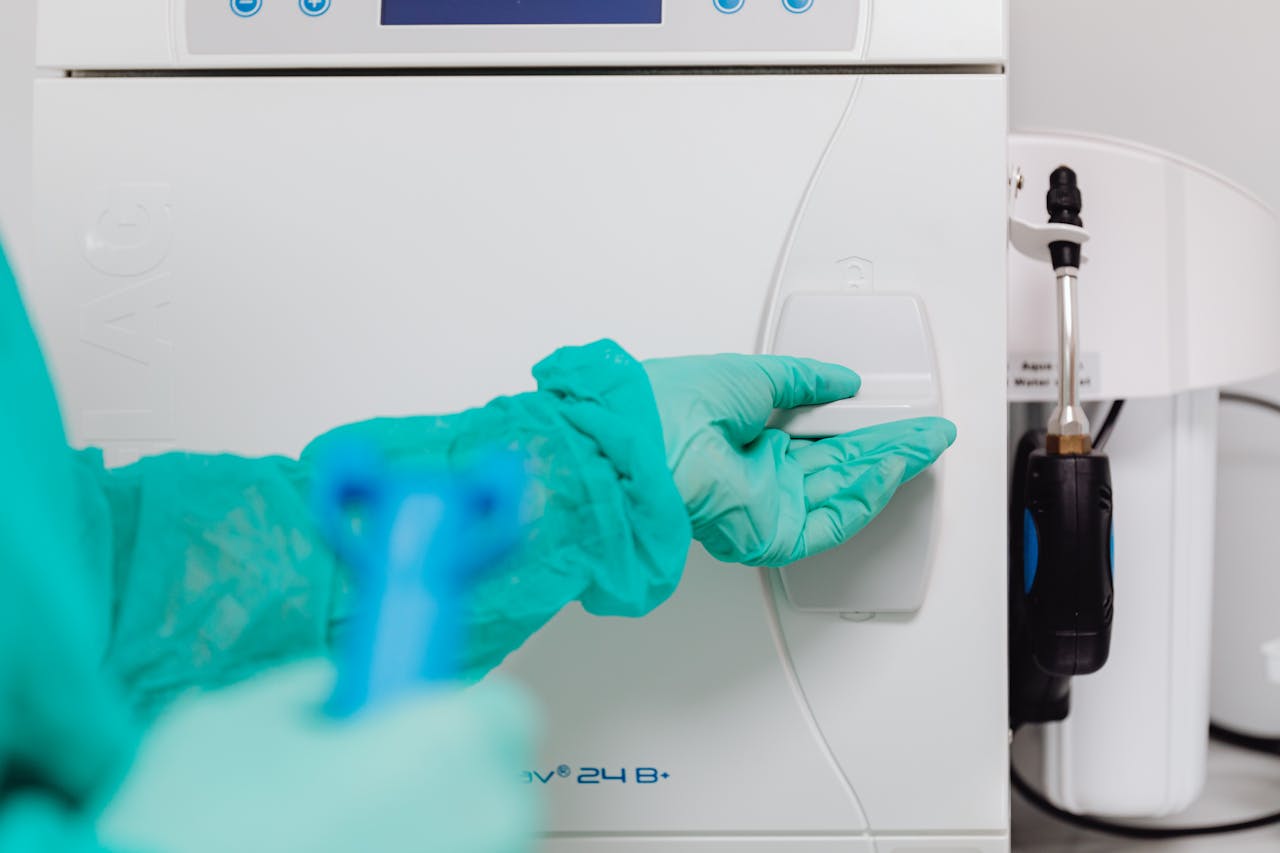 Close-up of operator using sterilization machine in a medical facility.